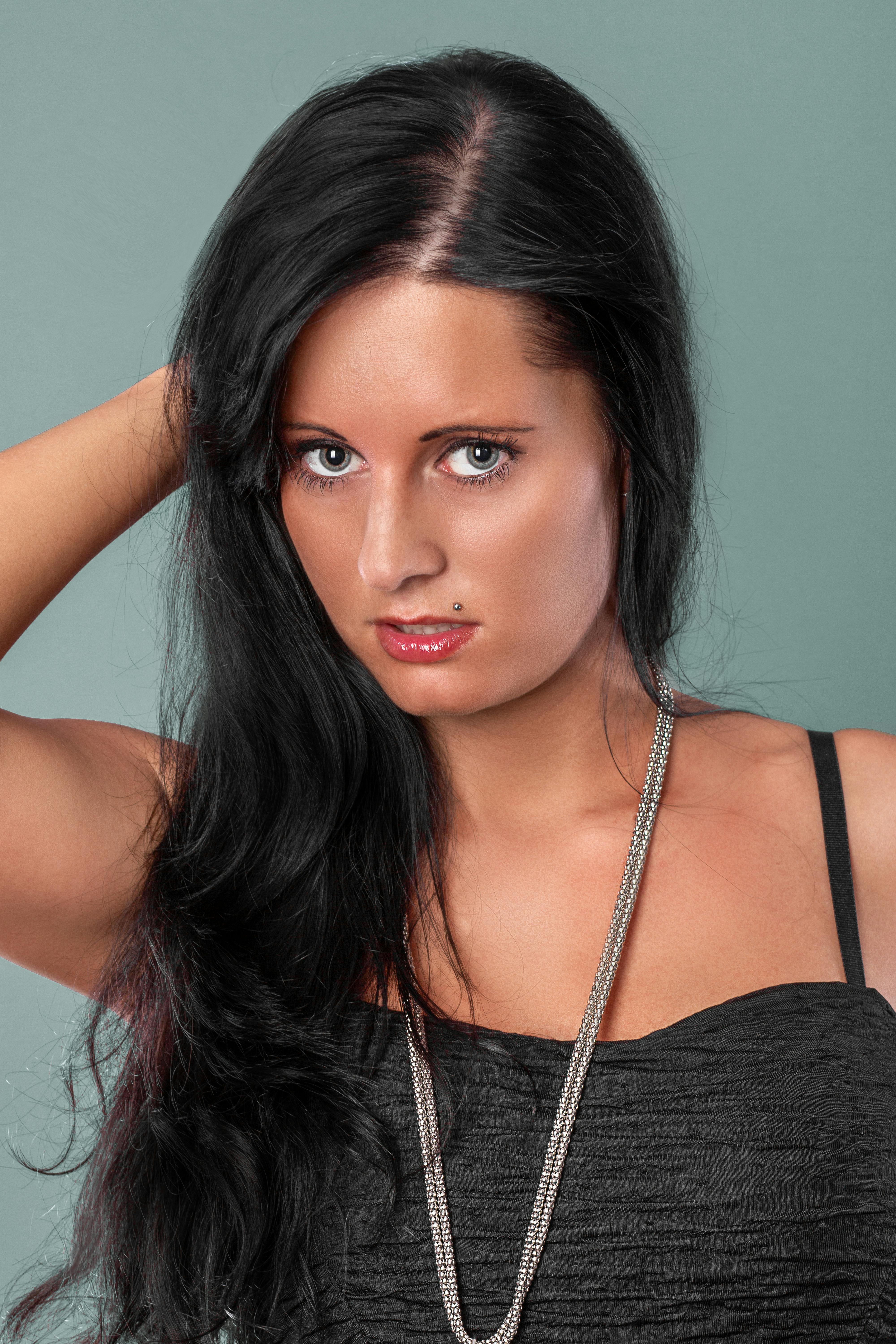 Gratis Potret penuh gaya seorang wanita dengan rambut hitam mencolok dalam suasana studio. Foto Stok