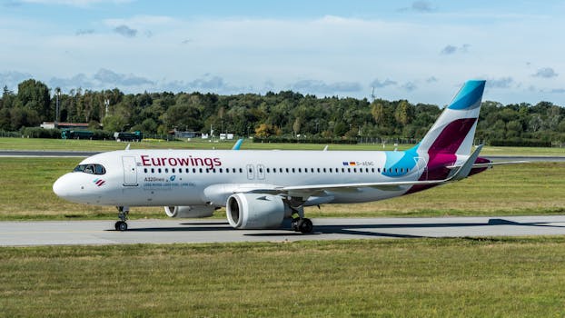 Eurowings Airbus A320neo taxiing at Hamburg Airport on a clear day.