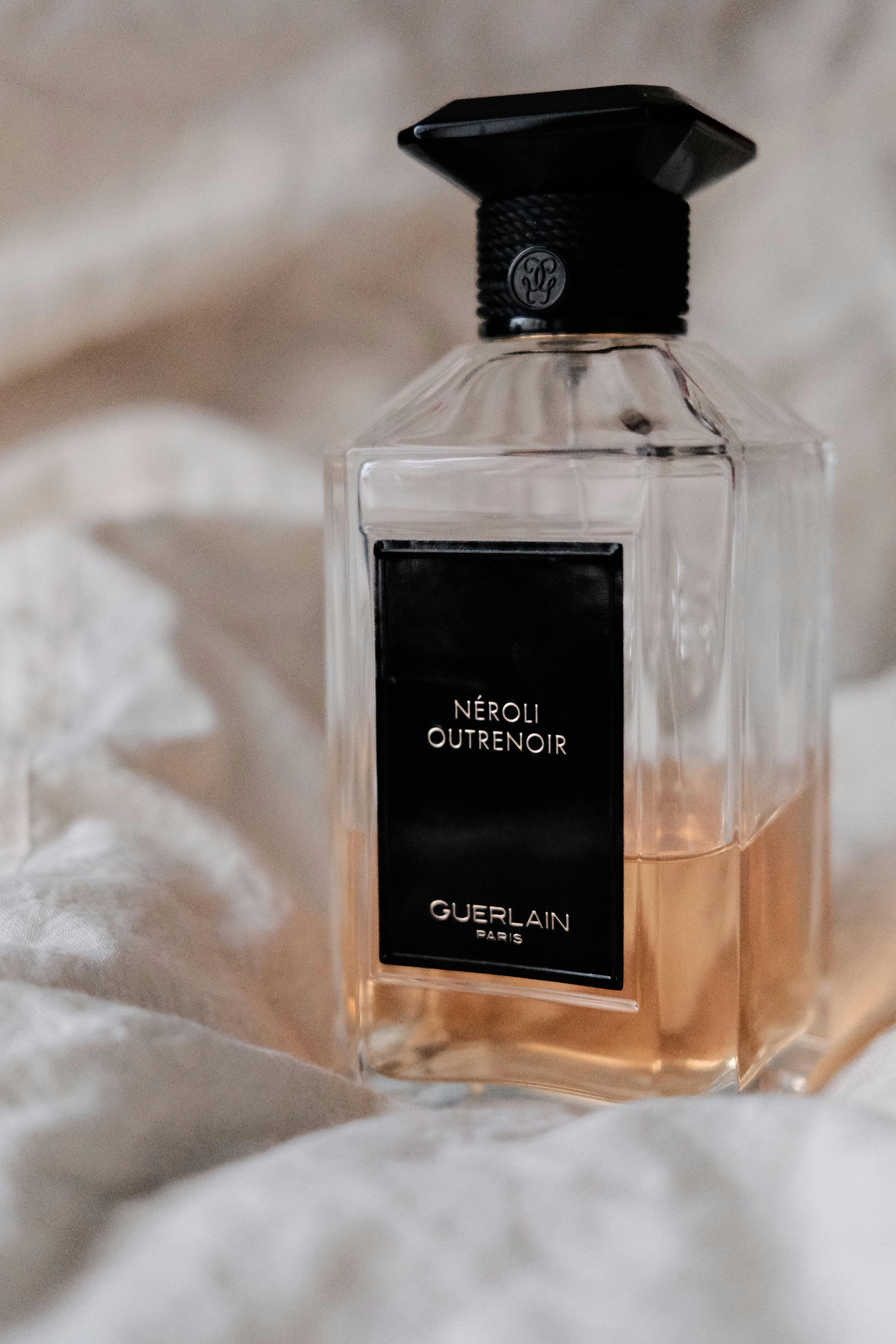 Elegant Neroli Outrenoir perfume bottle with soft fabric backdrop, exuding sophistication and luxury.