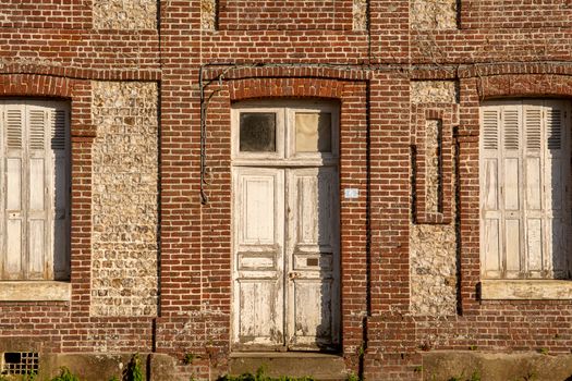 A vintage facade showcasing weathered wooden doors and brickwork under natural light.