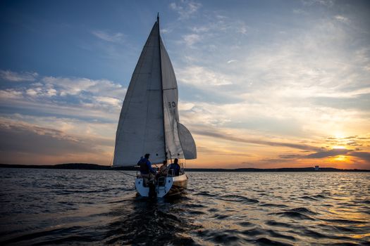 A peaceful sailing adventure on calm waters during a vibrant sunset, perfect for a tranquil escape.