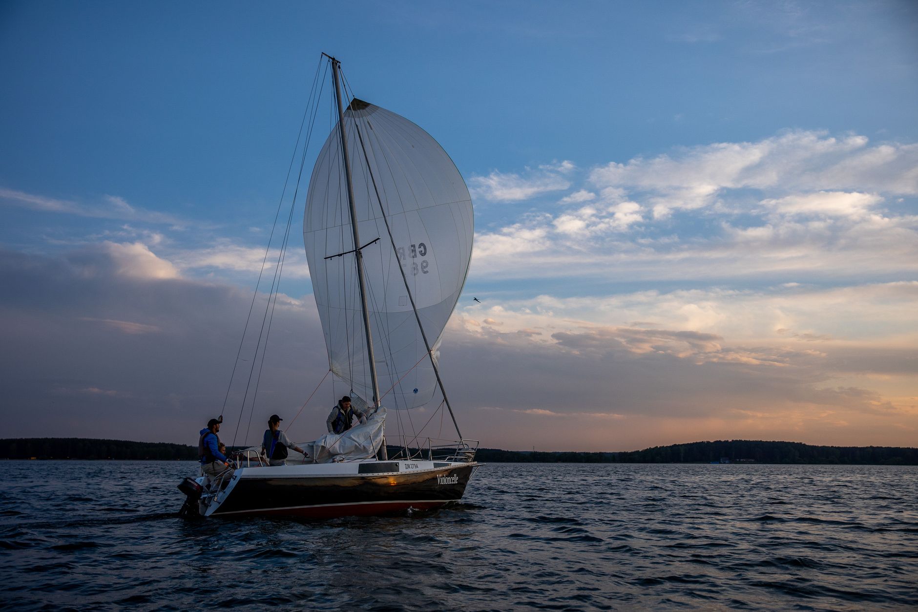 A sailboat glides across the water during a serene sunset, capturing the essence of adventure.