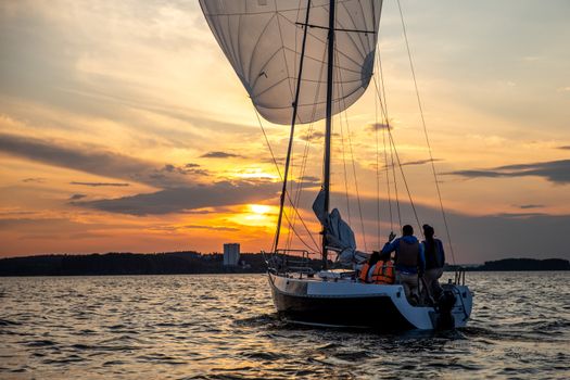 Sailboat on serene water during a vibrant sunset in Minsk Region, Belarus.