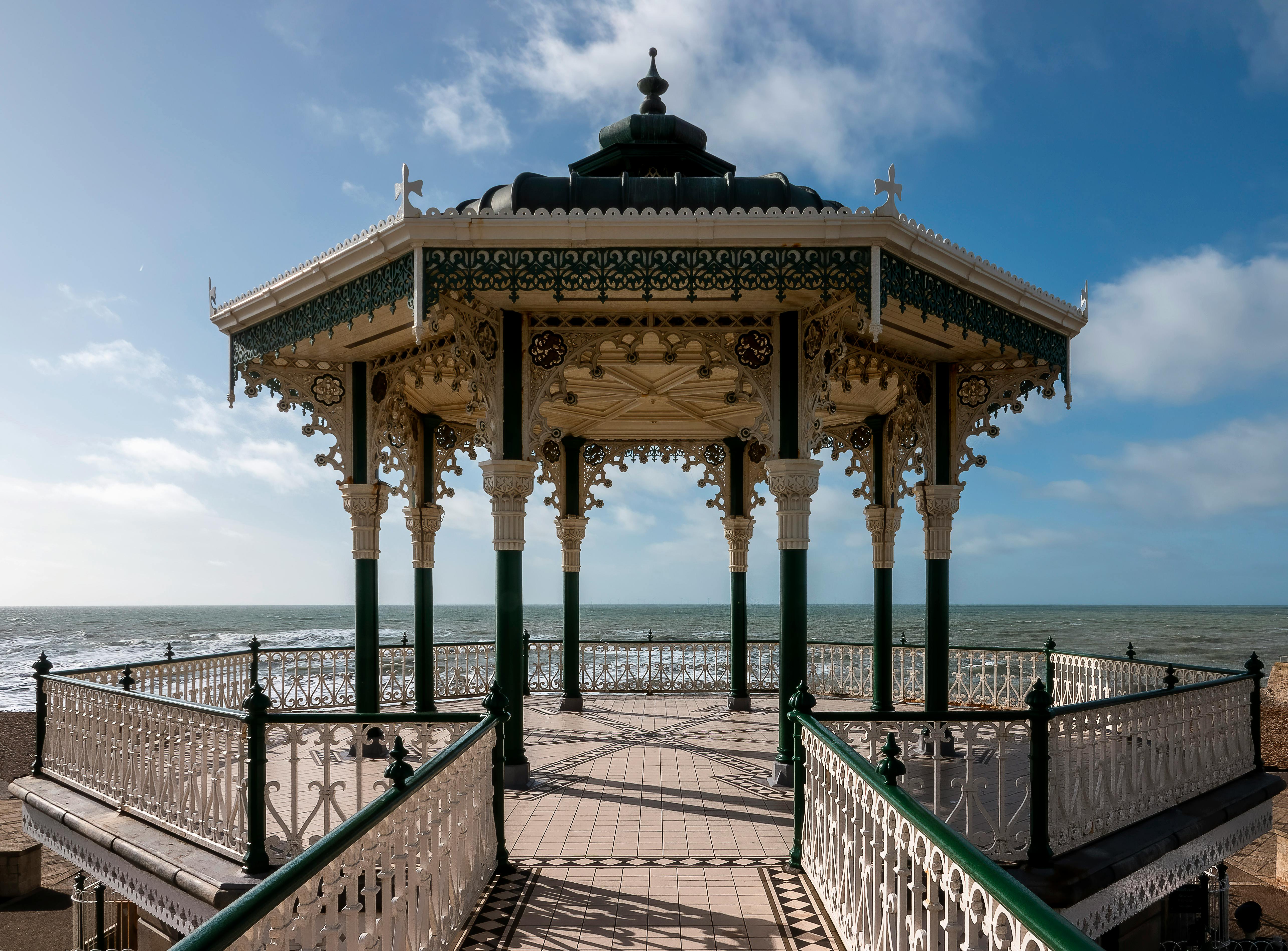 Ornate Victorian Bandstand in Brighton overlooking the sea, showcasing intricate ironwork and elegant design.