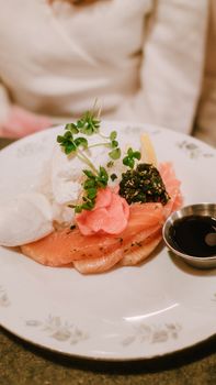 Elegant smoked salmon dish with rice, greens, and soy sauce, ideal for gourmet dining.