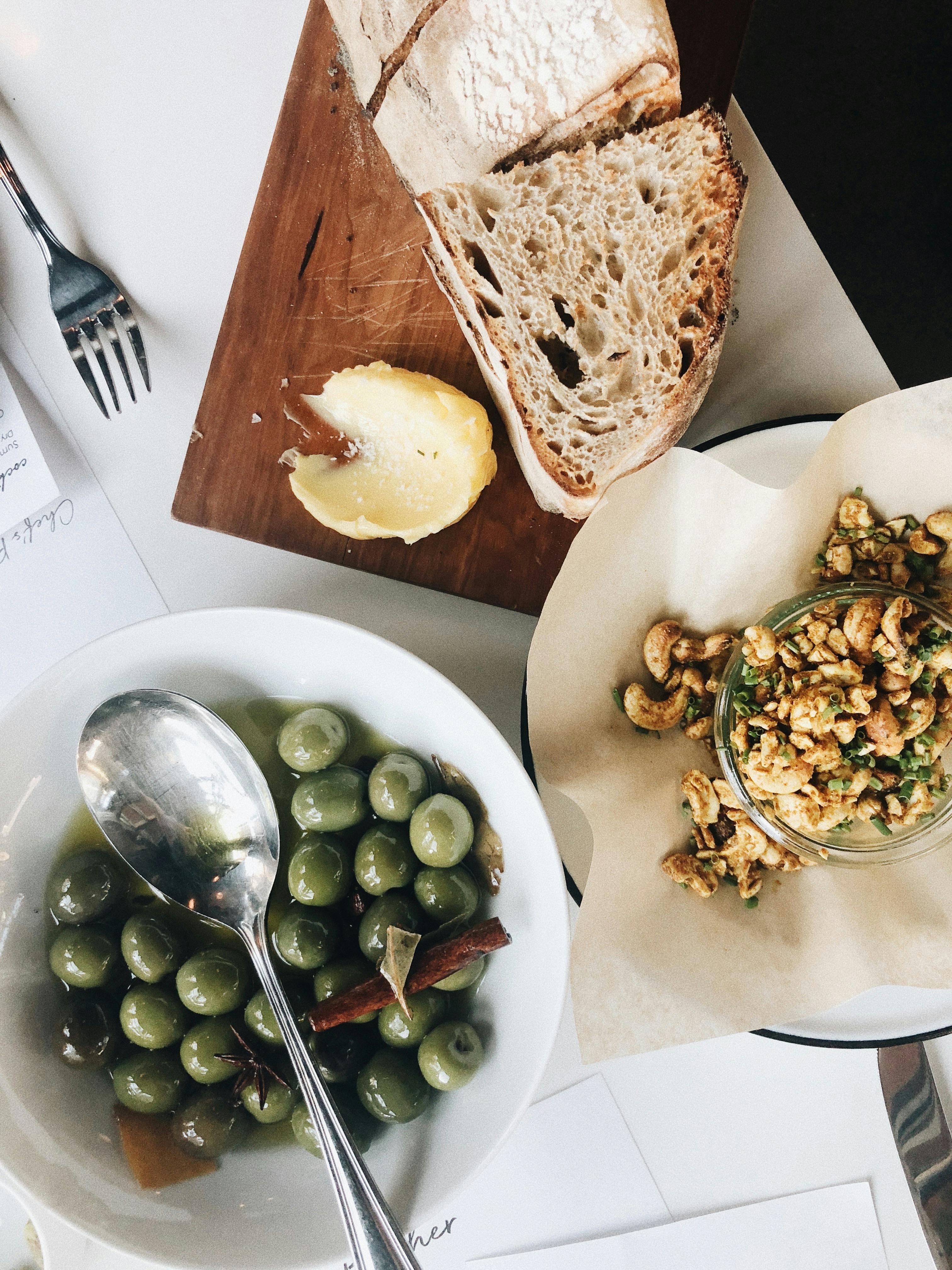 Artisan bread and green olives served with gourmet appetizers. Perfect for food enthusiasts.