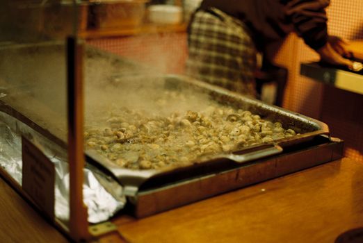 A steaming mushroom dish at a Berlin Christmas market food stall in the evening.