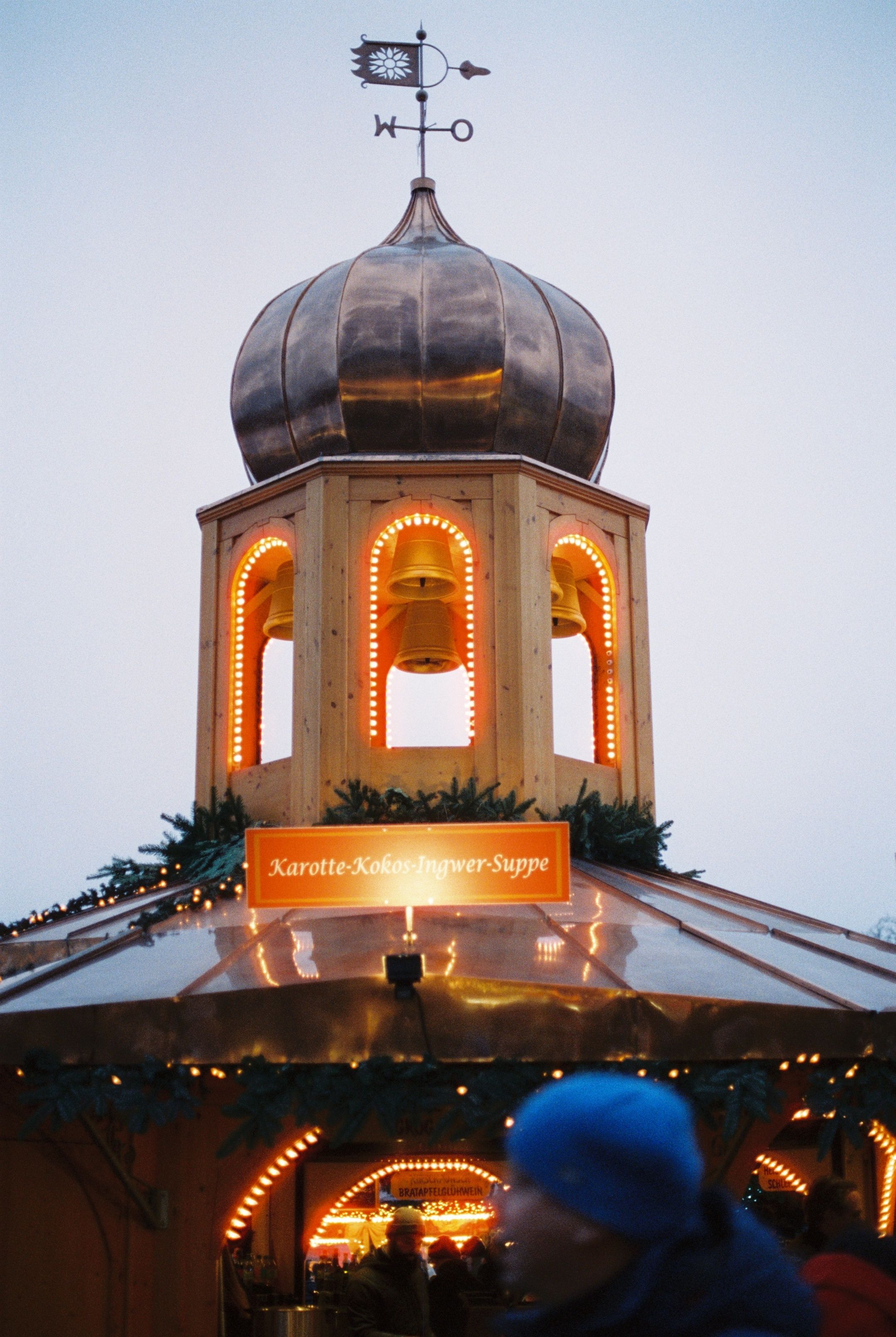 Illuminated tower at Berlin's Christmas market, creating a festive night scene.