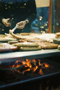 Authentic German sausages grilling over flames at Berlin's winter Christmas market.