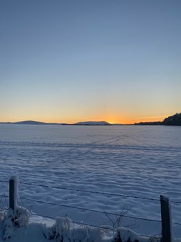 Breathtaking winter sunrise over snowy fields in Edinburgh, capturing serene beauty and calm.