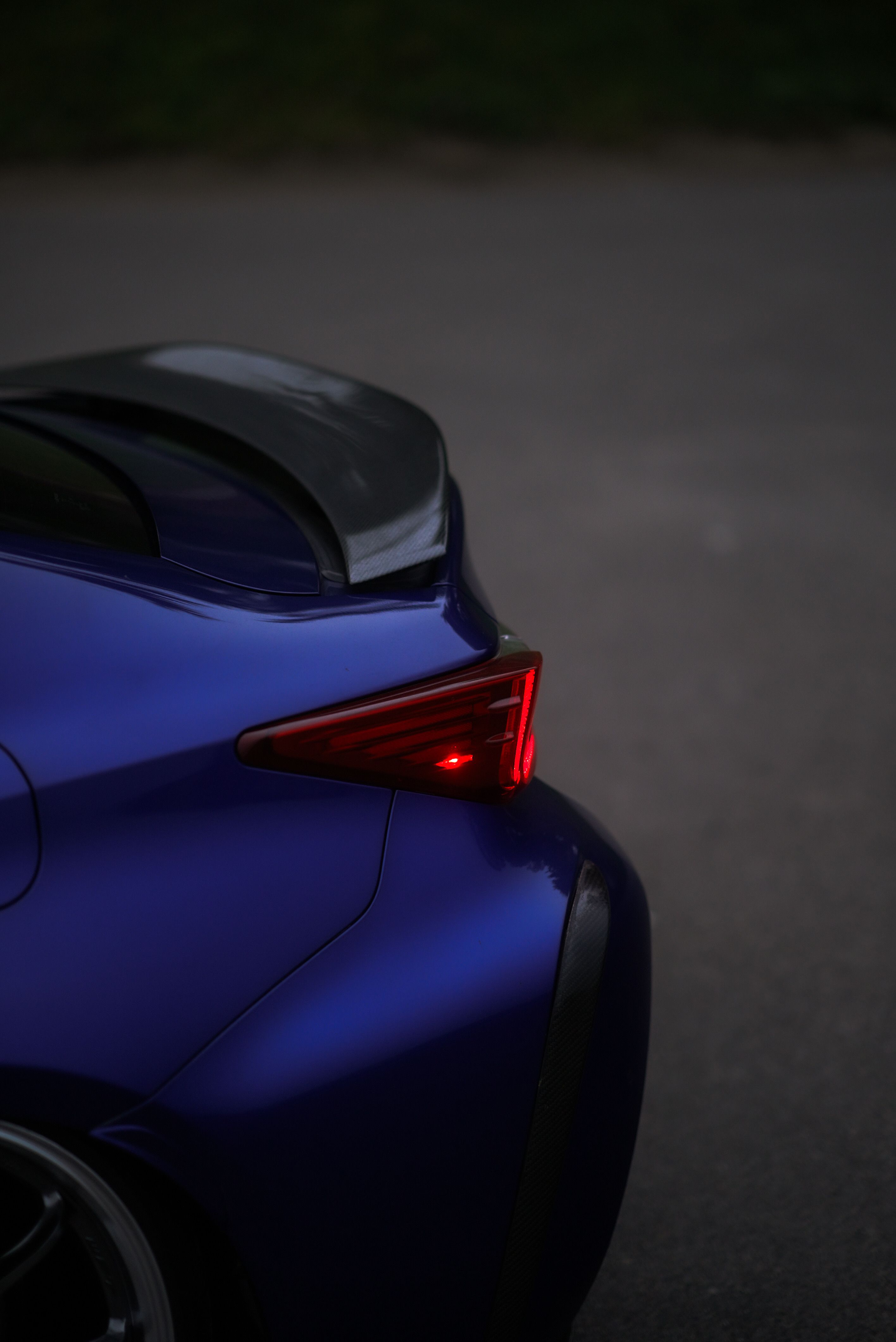 Dark Blue Sports Car with Illuminated Rear Light · Free Stock Photo