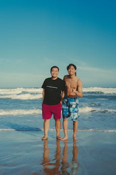 Two friends smiling at the camera on a sunny beach in Phan Thiet, Vietnam.