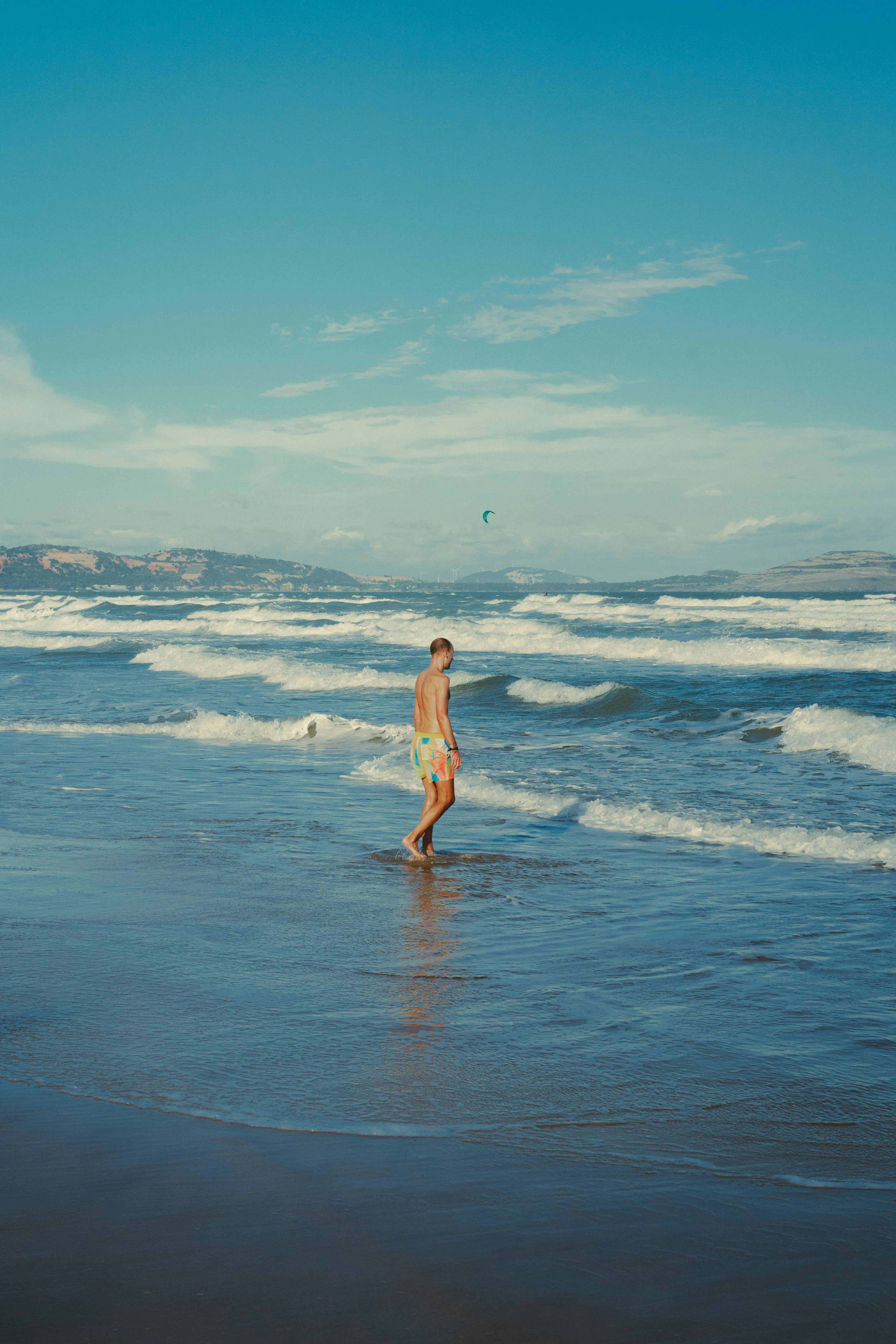 man walking on tropical beach at golden hour