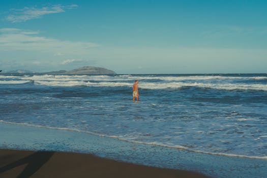 A man standing in the ocean on a beautiful tropical beach in Phan Thiet, Vietnam.