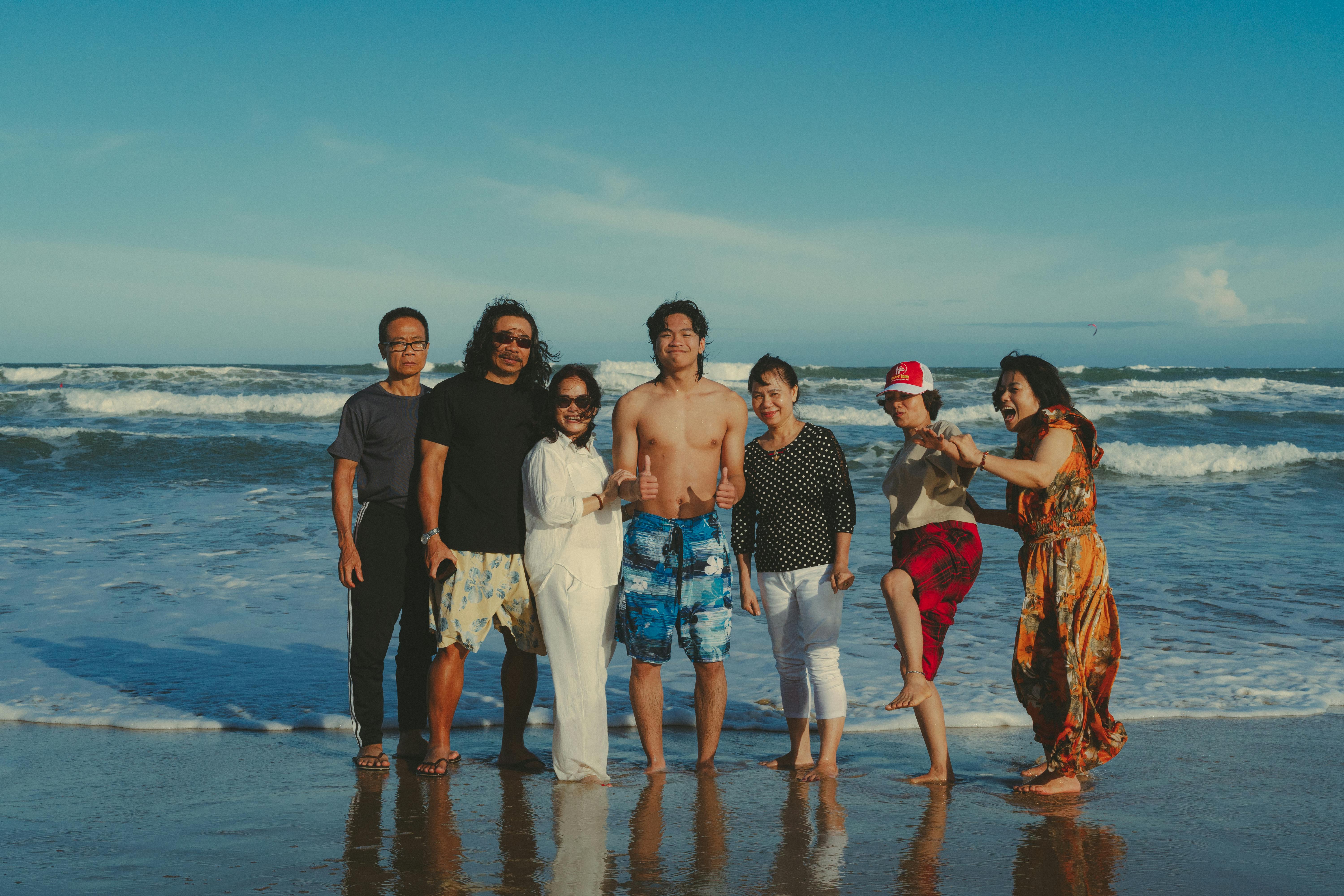 mixed generational asian family enjoying beach