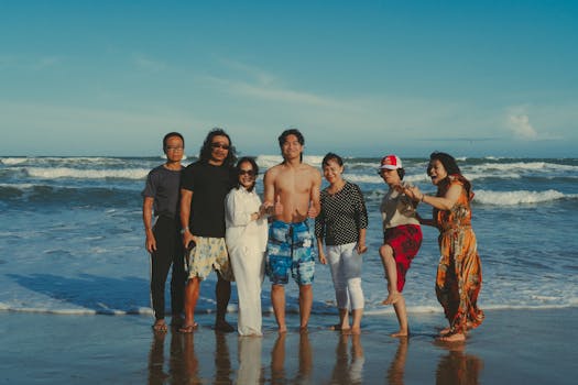 A joyful Asian family gathering at Phan Thiet beach in Vietnam during sunset.