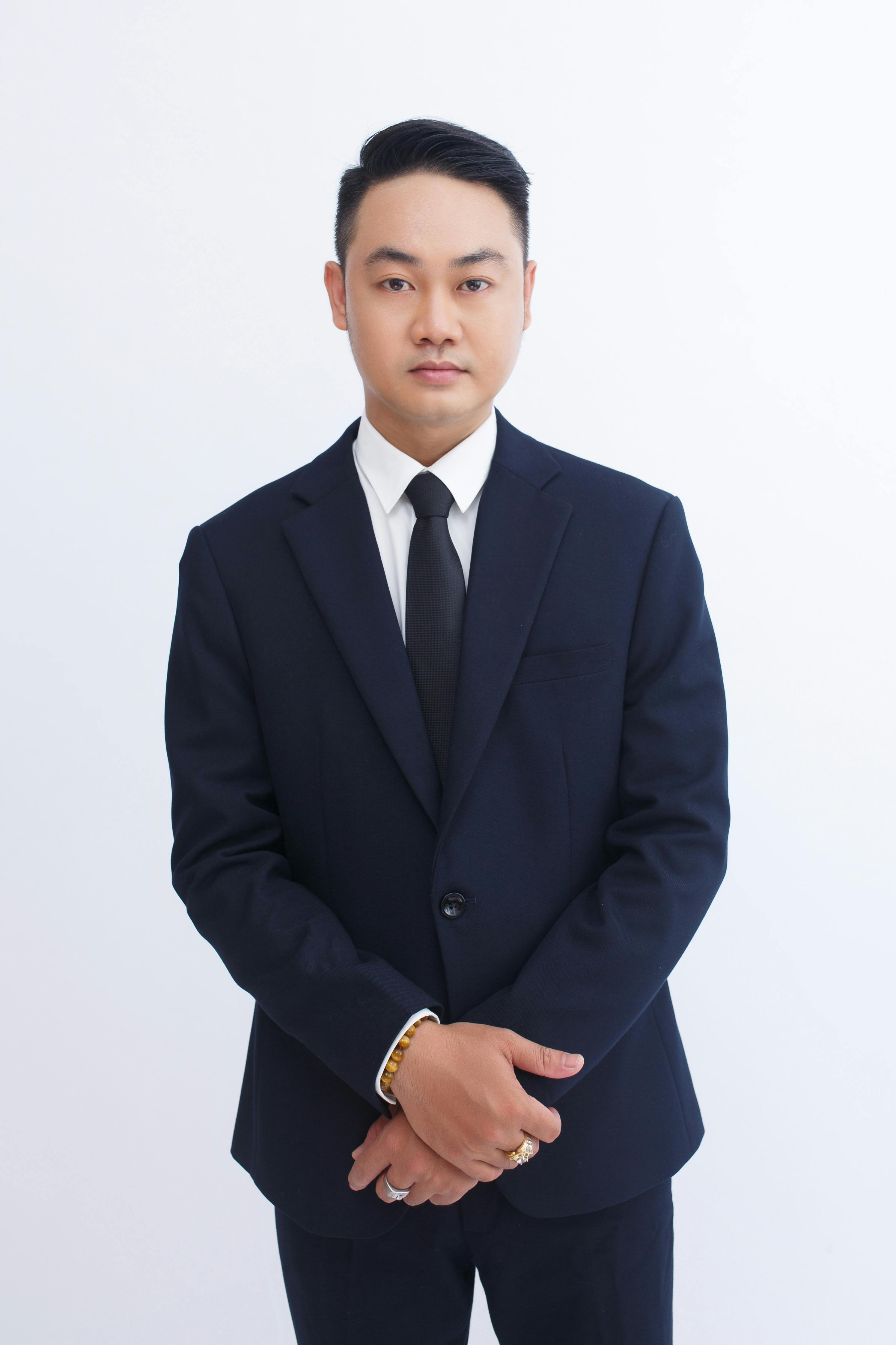 ฟรี ภาพถ่ายอันสง่างามของนักธุรกิจวัยผู้ใหญ่ในชุดสูทสีเข้ม แสดงท่าทางที่มั่นใจ คลังภาพถ่าย