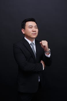 Elegant portrait of a confident businessman wearing a suit against a black background.