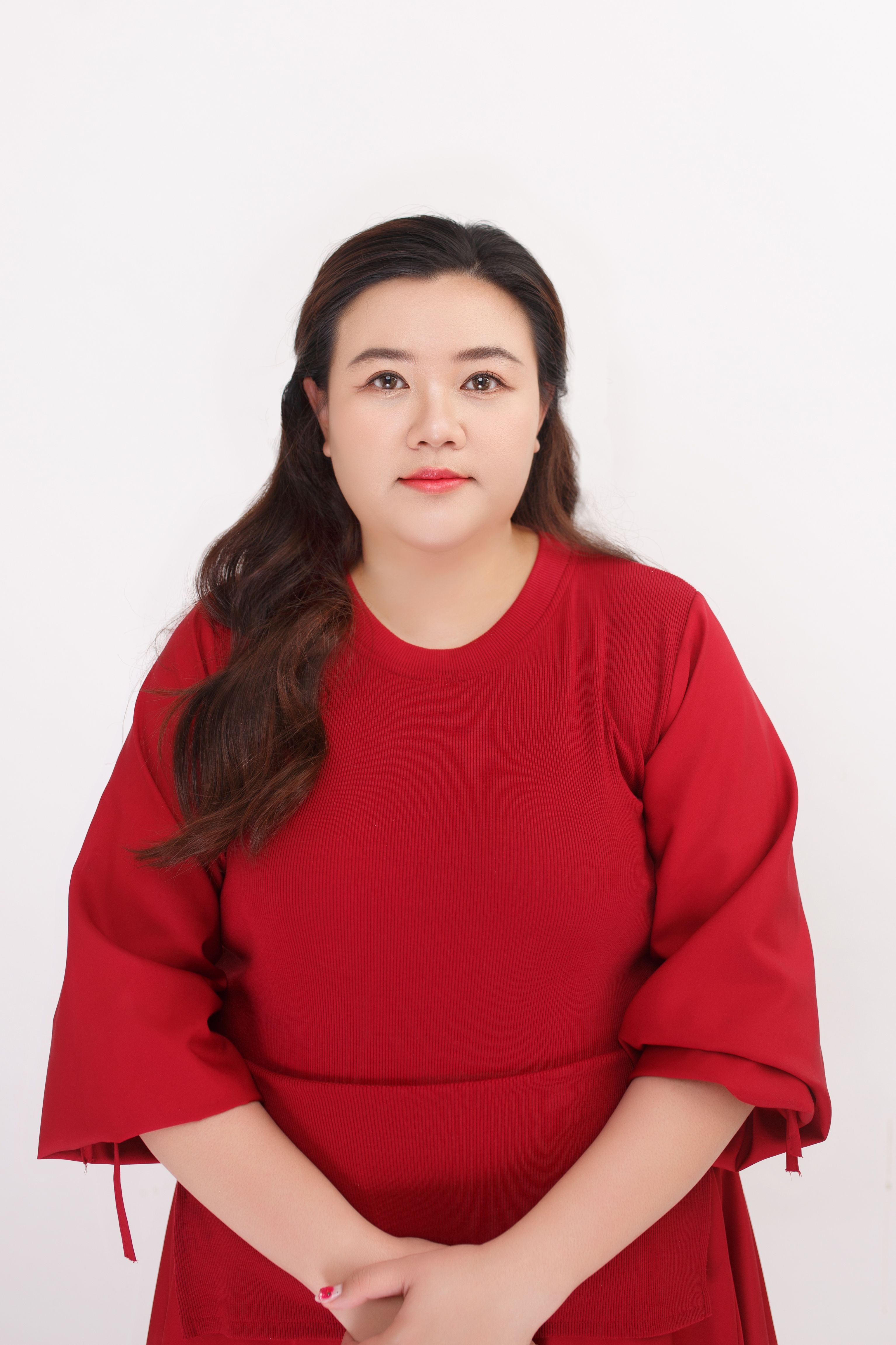 A woman in a red dress poses against a plain white background.