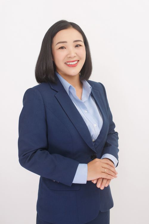 Free Confident female professional smiling warmly in a blue business suit on a white background. Stock Photo