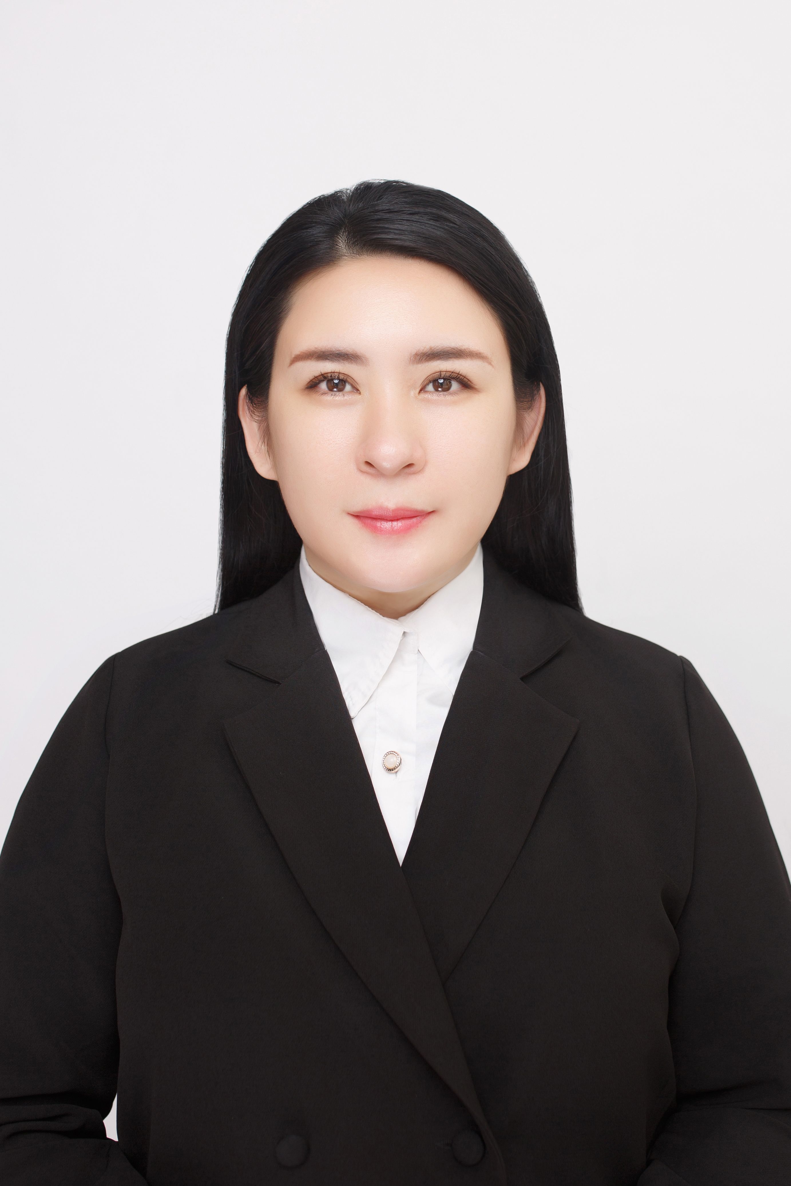 Studio portrait of a businesswoman in a black suit on a white background.