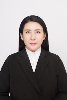 Studio portrait of a businesswoman in a black suit on a white background.