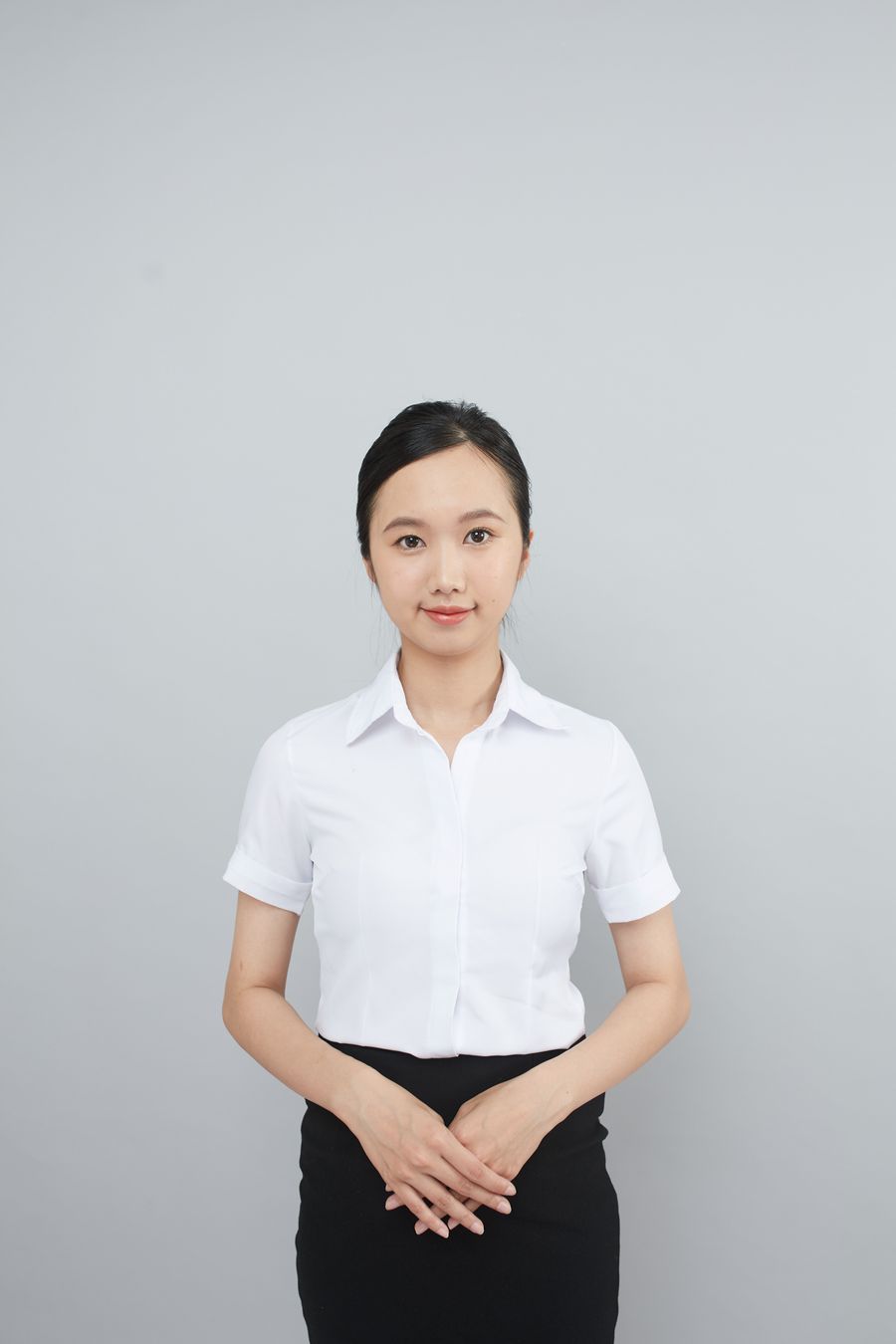 Presenter in formal attire against a plain backdrop, by Tran Nhu Tuan on Pexels