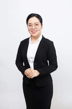 Confident businesswoman in a suit with a white background, ideal for corporate content.