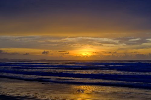 Free Breathtaking sunset over ocean waves with vivid sky and serene atmosphere. Perfect for tranquility themes. Stock Photo
