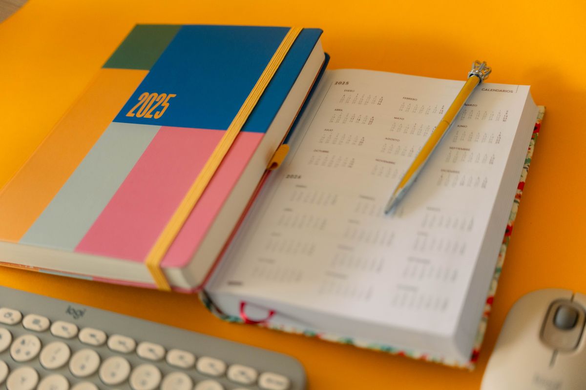 Colorful 2025 planner with keyboard and calendar, representing a structured plan to build semi-passive income