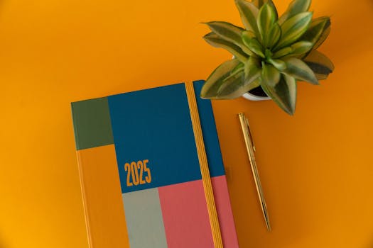Vibrant 2025 planner on yellow background with a pen and succulent.
