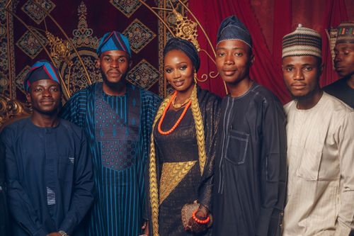 Free A vibrant group portrait showcasing five adults in elegant traditional African attire at a festive gathering. Stock Photo