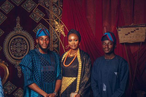 Free Three adults in traditional African clothing pose for a portrait with ornate background. Stock Photo