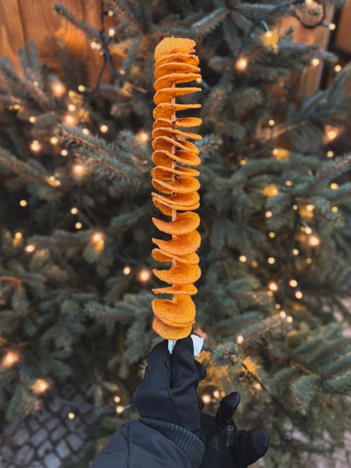 Free Delicious spiral-cut potato snack at a festive Berlin Christmas market. Stock Photo
