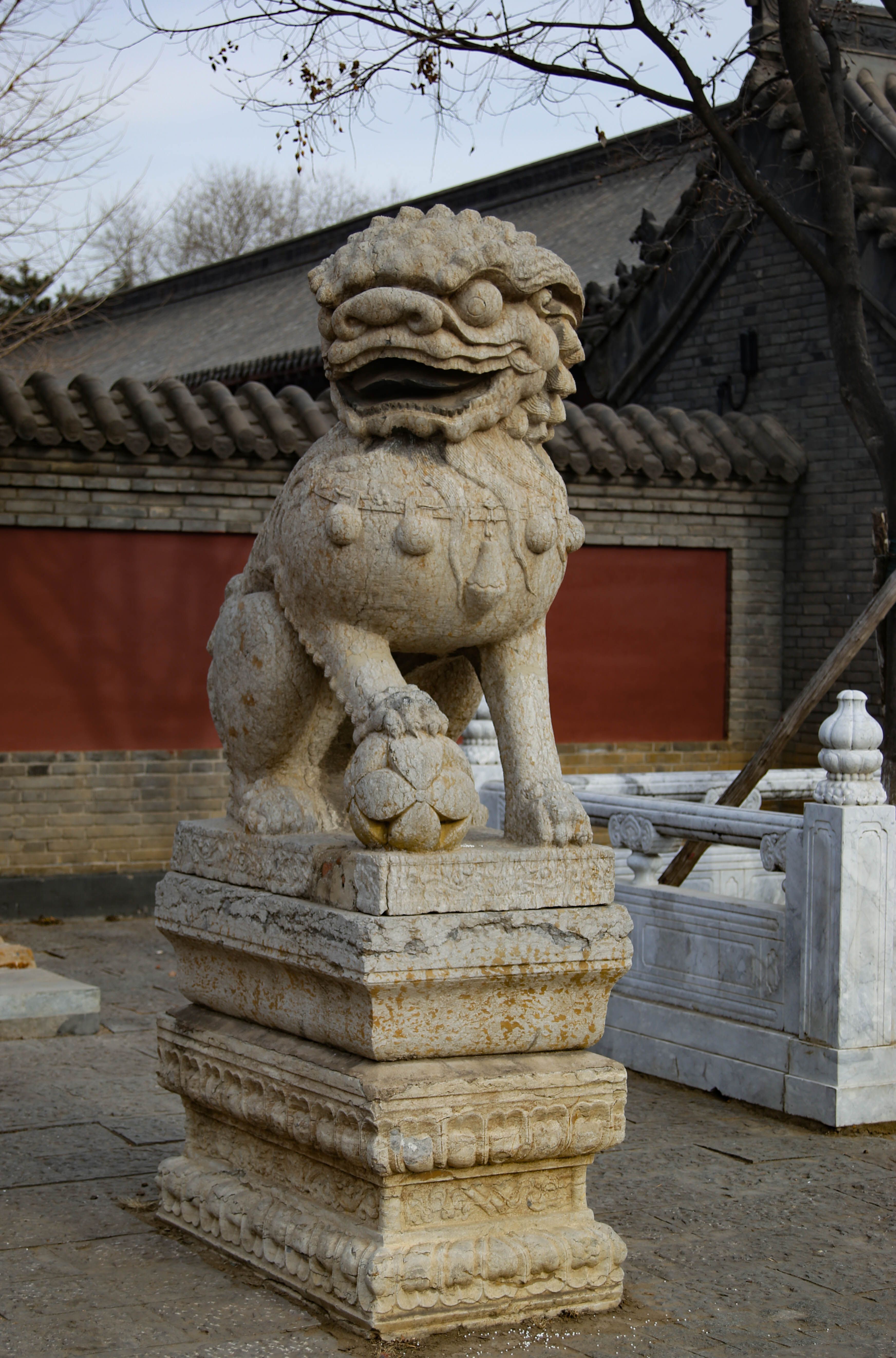 Gratuit Image détaillée d'une statue de lion gardien chinois en pierre dans un cadre de cour historique. Photos
