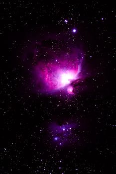 Captivating image of the glowing Orion Nebula amidst the stars in a deep purple hue.