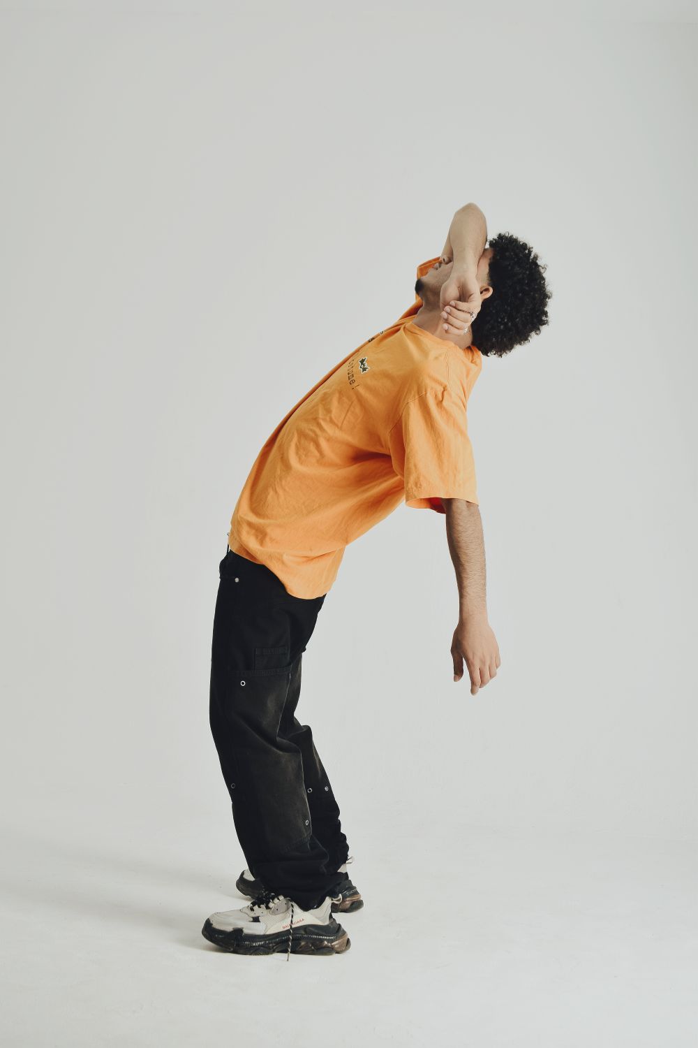 Expressive Model Expressive Male Model in Orange Shirt Studio Pose · Free Stock Photo