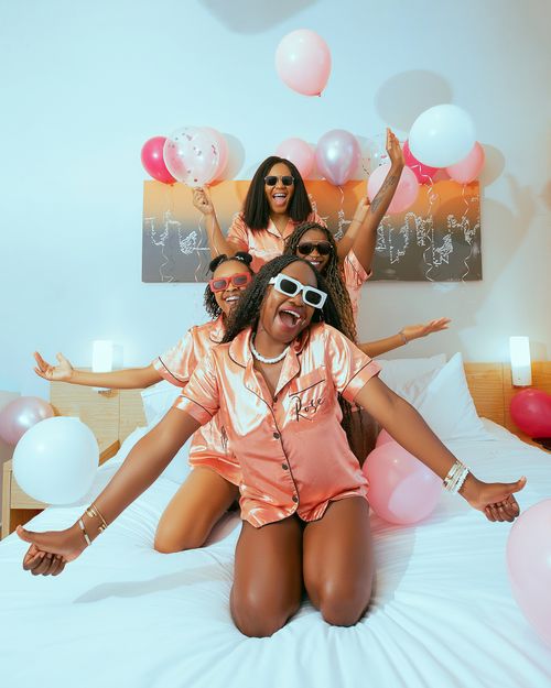 Free Group of women celebrating with balloons and laughter in stylish evening wear. Stock Photo