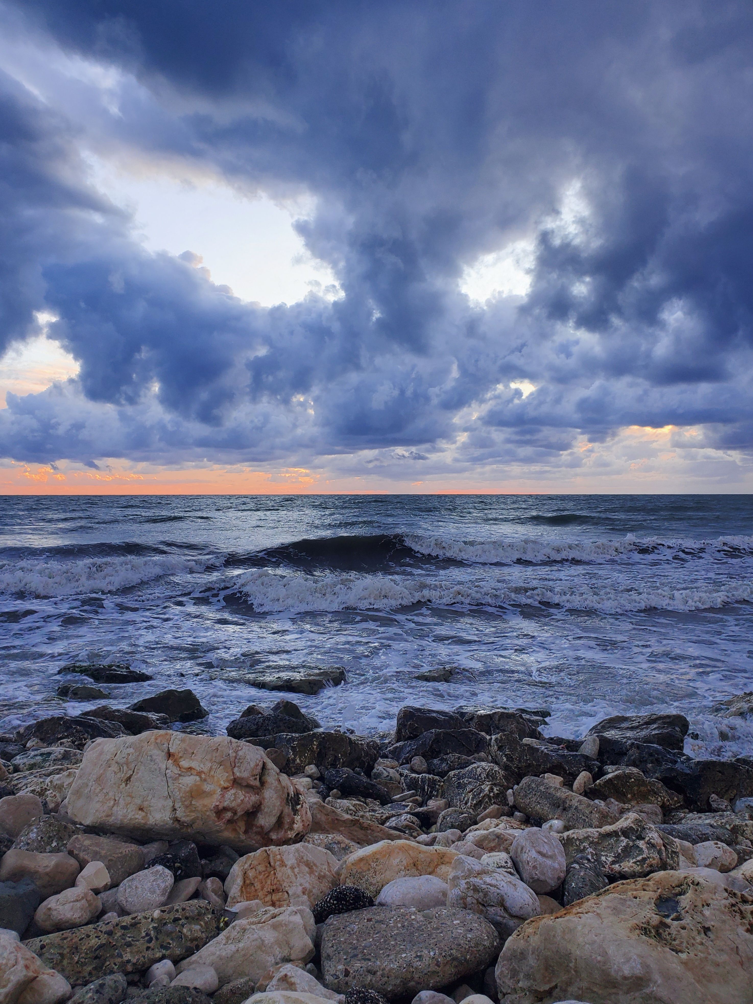 Dramatic Cloudy Sunset Over Rocky Beach · Free Stock Photo