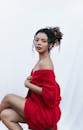 一位身穿红色浴衣的迷人女子，在白色背景下优雅地摆着姿势