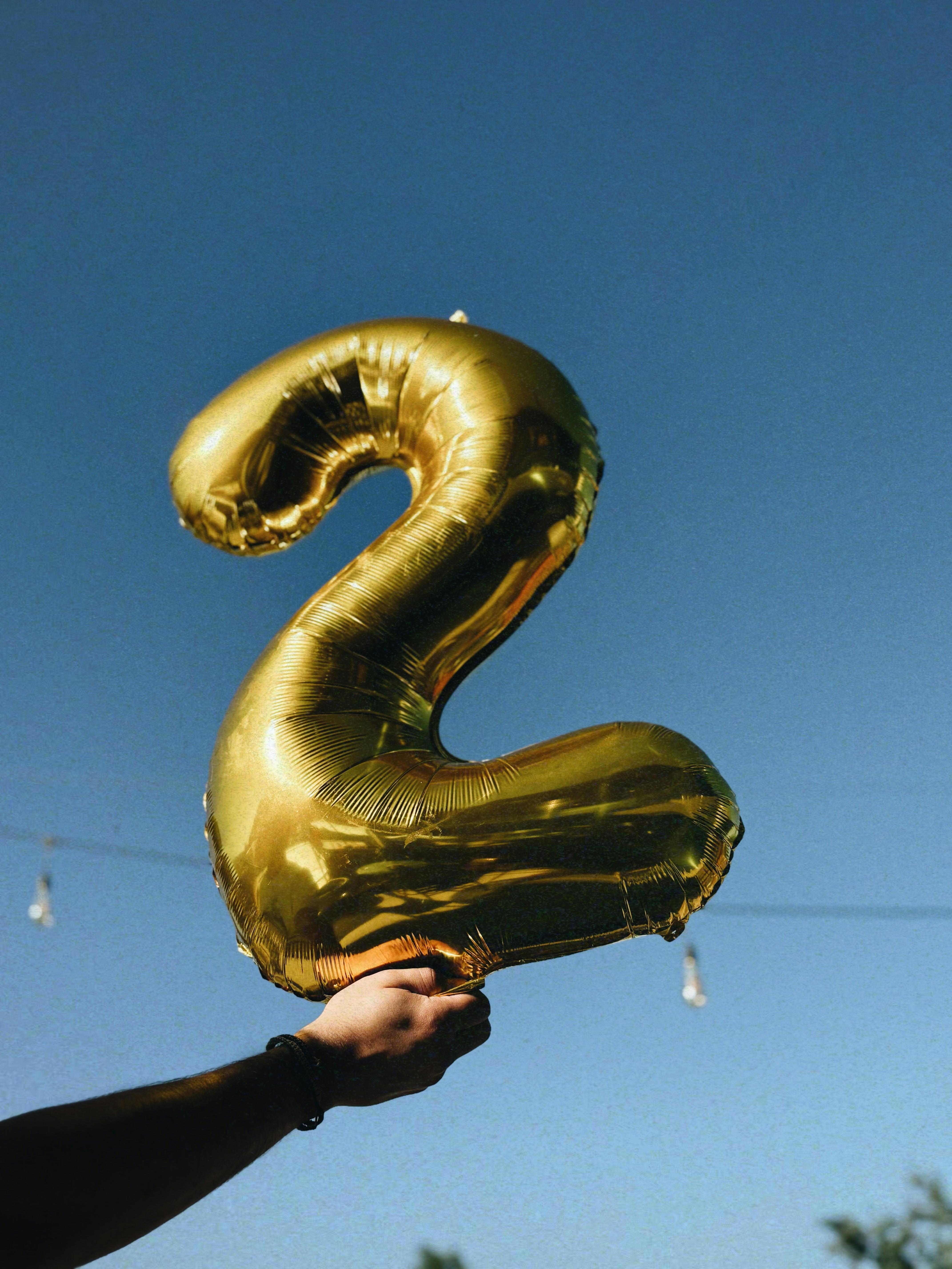 golden number two balloon against blue sky