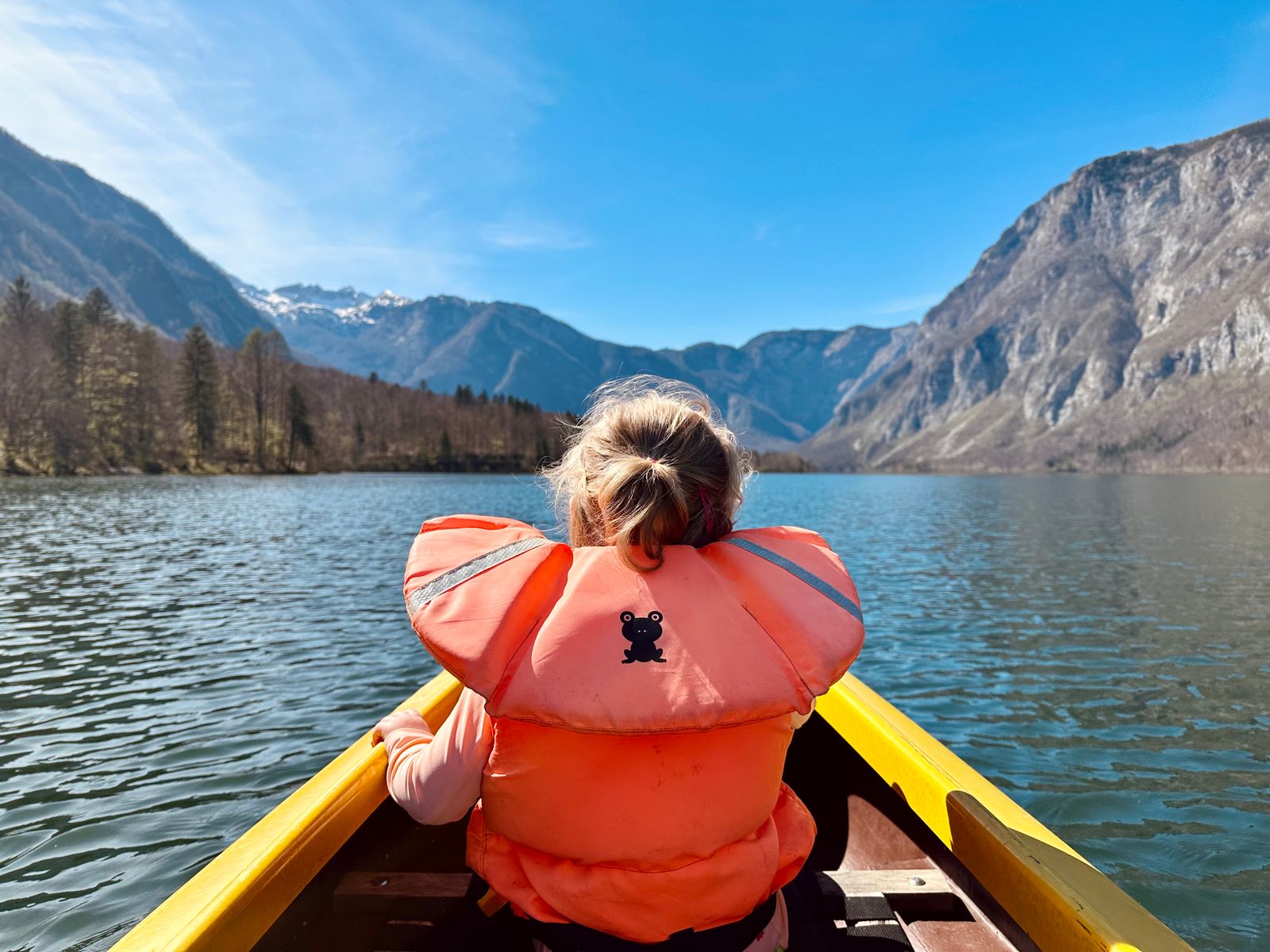 Child canoeing on a calm Slovenian lake
