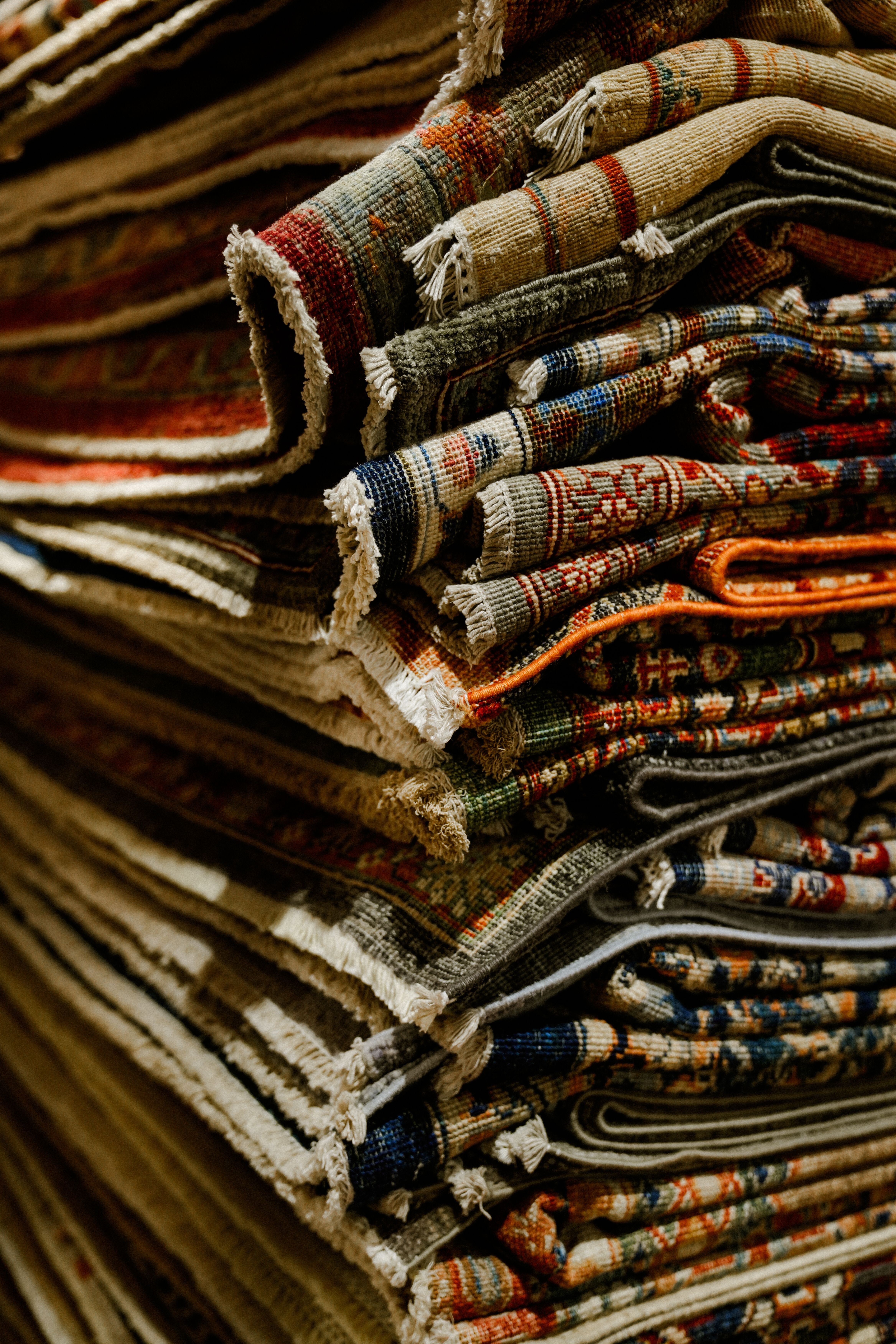 Stack of Colorful Oriental Rugs with Intricate Patterns · Free Stock Photo