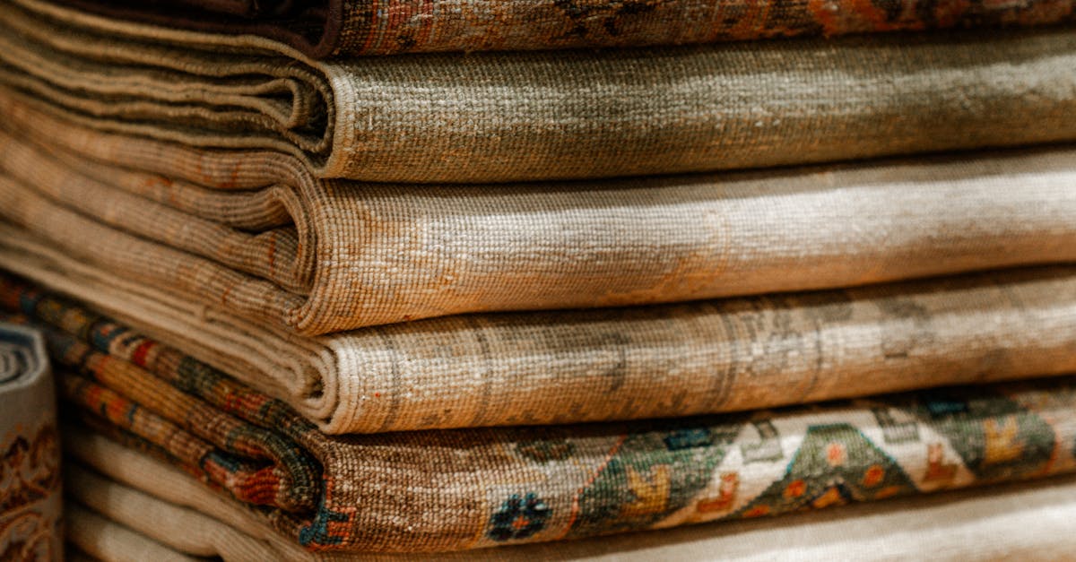 Stack of Ornate Handmade Persian Rugs on Display · Free Stock Photo