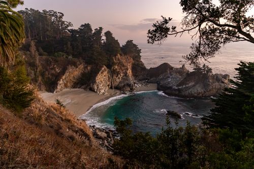 Free Captivating sunrise over McWay Falls in Big Sur, showcasing cliffs, sand, and ocean. Stock Photo