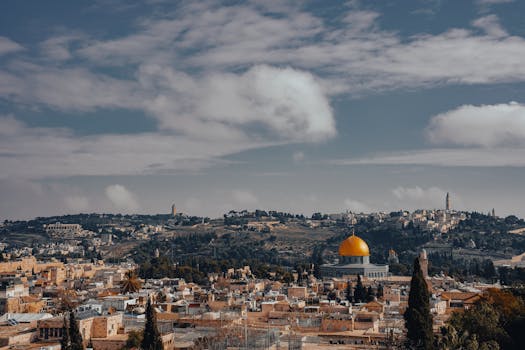 Stunning aerial view of Jerusalem cityscape with iconic Dome of the Rock amidst historical landmarks.