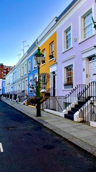 Vibrant row of pastel-colored houses on a quiet street in London, UK.