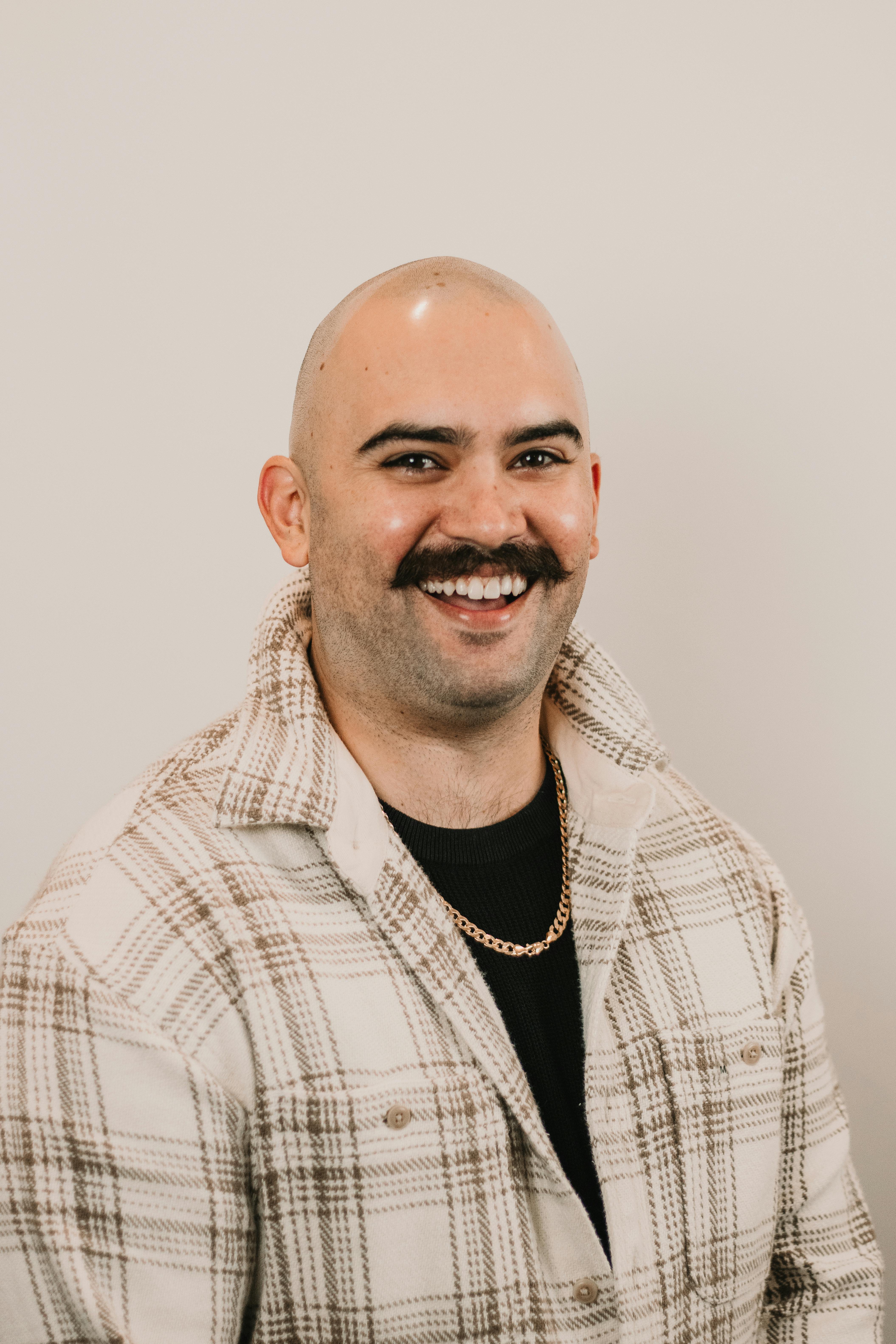 A confident professional posing with a smile against a neutral background.