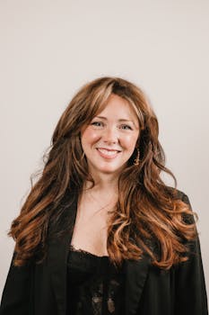Elegant headshot of a professional woman in a black outfit, showcasing confidence and style.