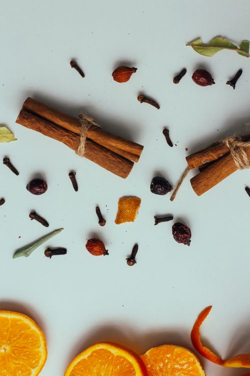 Free A flat lay of cinnamon sticks, cloves, and orange slices, perfect for culinary themes. Stock Photo